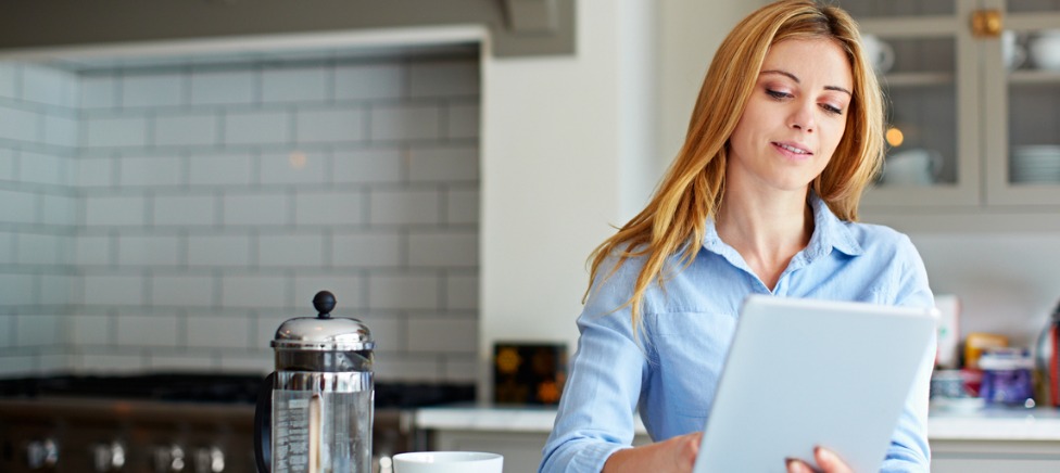Woman in kitchen using tablet Woman in kitchen using tablet