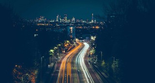 Road to a city at night with neon lights